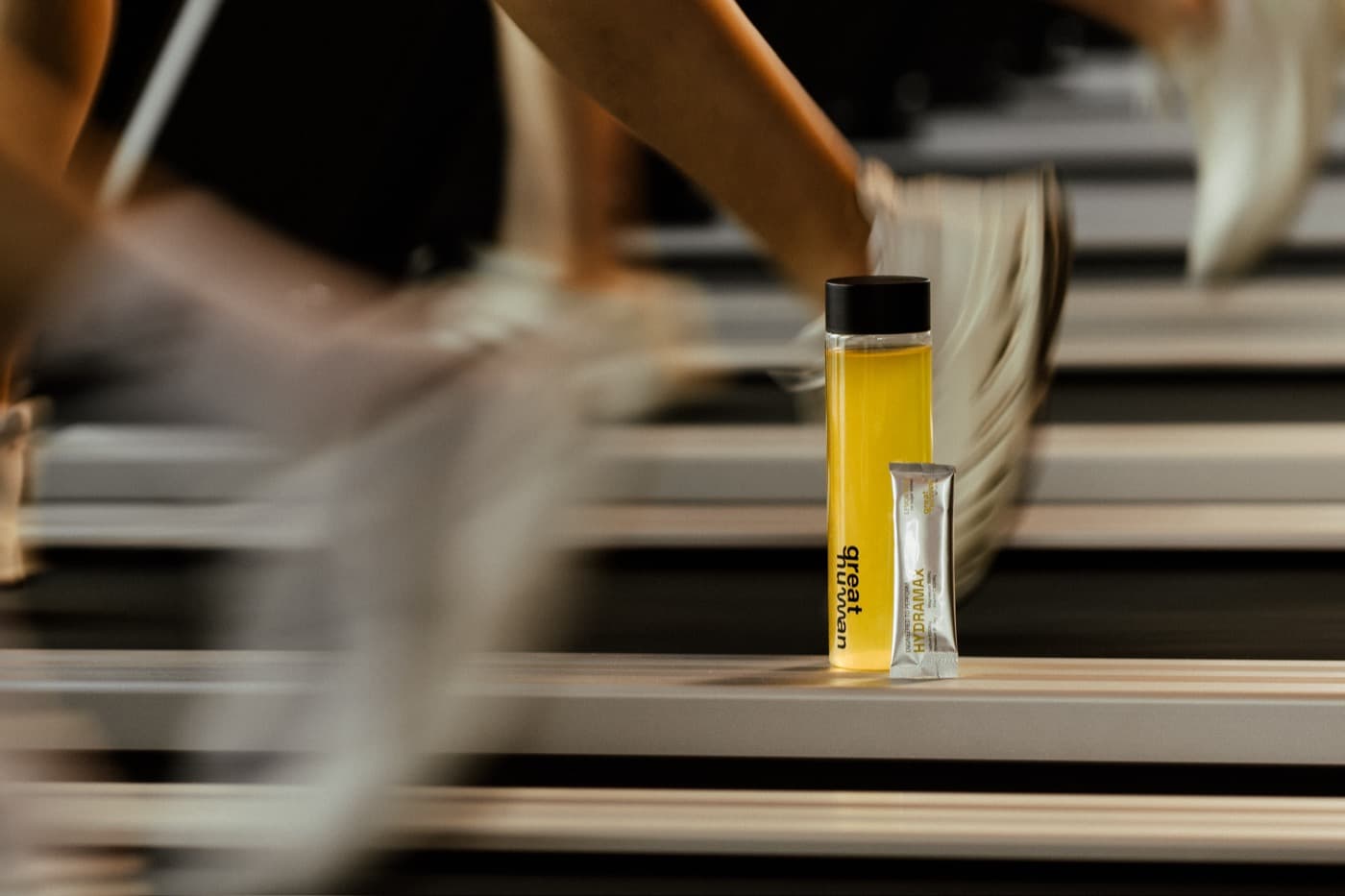 Electrolyte drink and sachet beside a treadmill mid-session